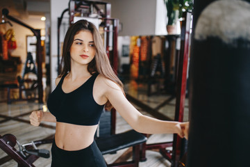 Fototapeta na wymiar Beautiful girl in the gym. A woman performs exercises. The girl is boxing