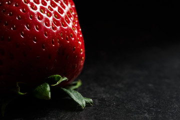 Strawberries on black textured background, dark food