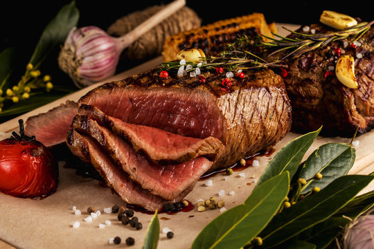 Grilled beef steak with rosemary, salt, pepper, garlic and Bay leaf on a chopping Board