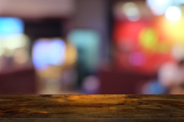 Empty dark wooden table in front of abstract blurred bokeh background of restaurant . can be used for display or montage your products.Mock up for space.