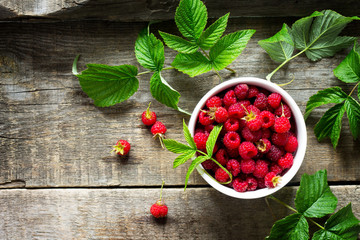 Berry raspberries on a wooden table rustic. Natural detox, fruit dessert, healthy dieting concept. Top view flat lay background. Free space for your text.