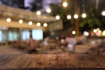 Empty dark wooden table in front of abstract blurred bokeh background of restaurant . can be used for display or montage your products.Mock up for space.