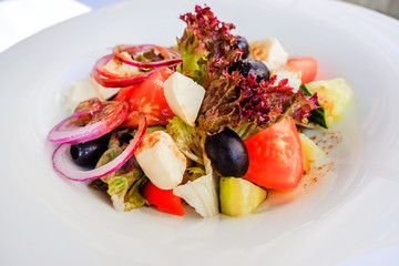 Greek salad with feta cheese, organic kalamata olives, juicy tomatoes, red pepper, red onion, cucumber and lettuce. Concept for healthy nutrition. Tasty and healthy vegetarian meal. Diet and healthy