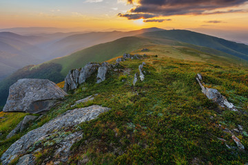 Mountain scenery in the Ukrainian Carpathians in the summer with a tourist in the background of the sunset