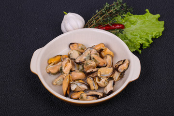 Pickled mussels in the bowl served pepper, garlic and salad