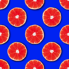 Seamless pattern made of red tangerine on a bright blue background