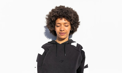 Fototapeta premium Women with Afro-black hair in front of white wall