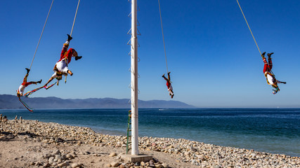 Papantla flyers with a wonderful blue sky, an ancient Mexican tradition (mexican pre-columbian aerial dance), wonderful sunny day on the beach of Puerto Vallarta Jalisco Mexico