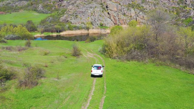 Off road pickup truck driving in  beautiful landscape with river and rocks. Aerial 4k view  