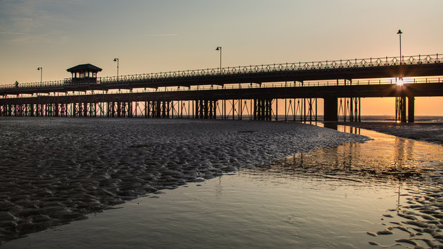 Sunrise through the pier from the beach at Ryde, Isle of Wight