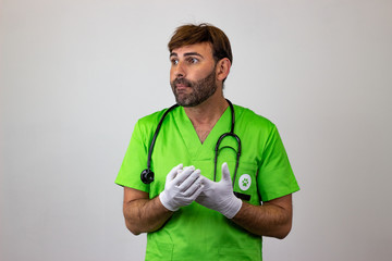 Portrait of male veterinary doctor in green uniform with brown hair looking ashamed, facing...