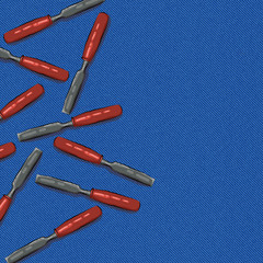 bit tool with orange handle on blue denim background with space for text