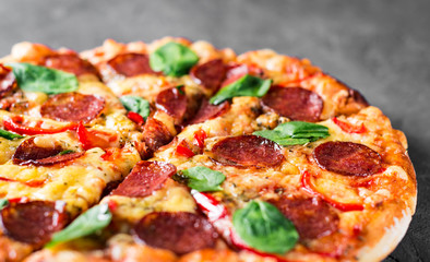 Pepperoni Pizza with Mozzarella cheese, salami, pepper, Spices and Fresh spinach. Italian pizza on...