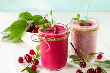 Cherry and raspberry fruit Yogurt smoothie or milk shake in glass jar on a wooden table. Natural detox, fruit dessert, healthy dieting concept.