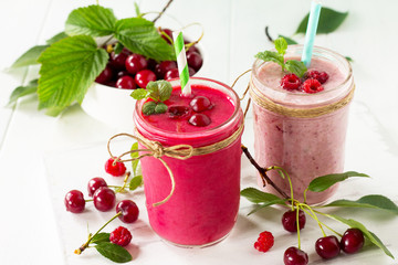 Cherry and raspberry fruit Yogurt smoothie or milk shake in glass jar on a wooden table. Natural detox, fruit dessert, healthy dieting concept.