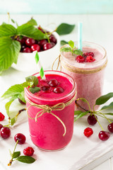 Cherry and raspberry fruit Yogurt smoothie or milk shake in glass jar on a wooden table. Natural detox, fruit dessert, healthy dieting concept.