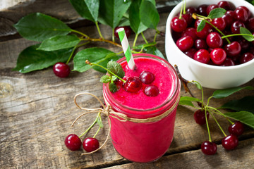 Cherry fruit Yogurt smoothie or milk shake in glass jar on a wooden rustic table. Natural detox, fruit dessert, healthy dieting concept. Free space for your text.