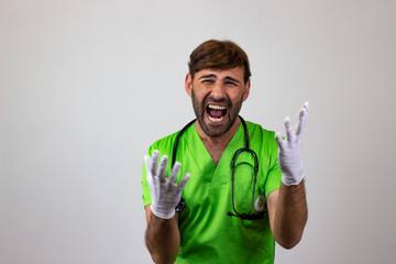 Portrait of male veterinary doctor in green uniform with brown hair looking euphoric, looking at...