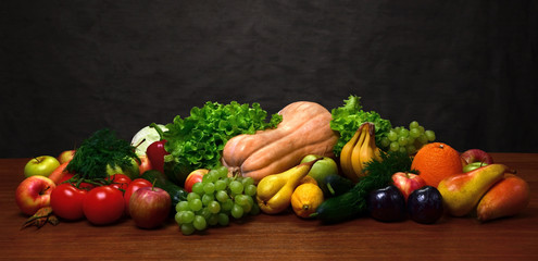 Vegetables and fruits on the oak table and on wooden background.
