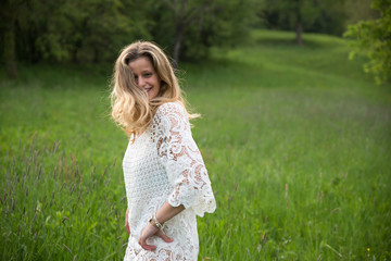 Fototapeta na wymiar Young happy caucasian woman playing in a meadow full of flowers. Nature and happiness concepts