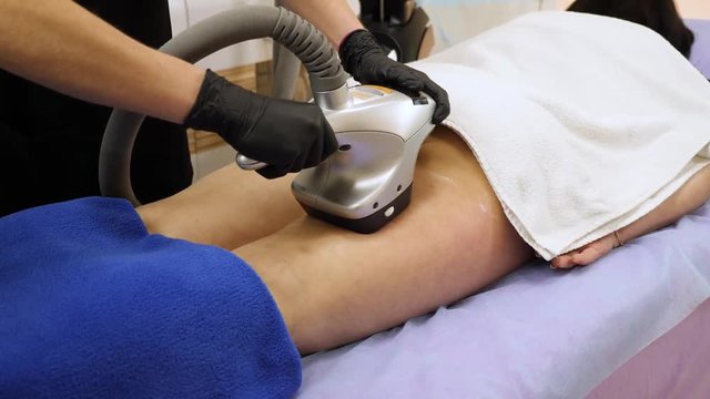 Woman getting belly massage with velashape machine at beauty salon