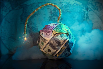 The world of money is burning.Financial bomb explodes.Smoke,fuse.Dollar and Euro decrease. Global economic recession concept.World map in the background.