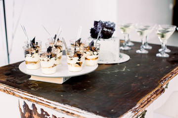 Party celebration concept, food and desserts. Tasty birthday cake, tiramisu desserts and alcohol drinks on the vintage wooden table