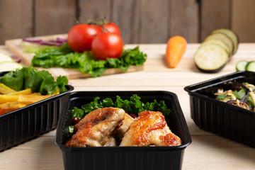 side view of ready meal to eat, roast chicken wings with pasta and cheese, vegetables background