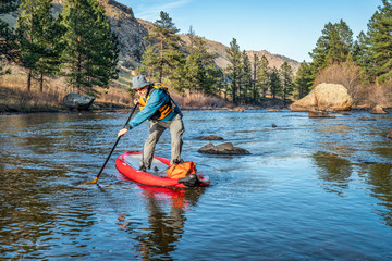 stand up paddling on mountain river