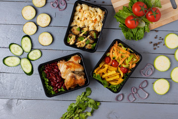 baked pasta with cheese, grilled chicken wings with raw vegetables, top view