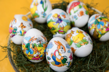 osterei mit osterhase auf gelbem untergrund in nahaufnahme fotografiert zu ostern an einem sonnigen tag in farbe