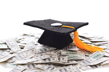  Mortarboard on a pile of money representing the high cost of education, Student Loans and Bribery