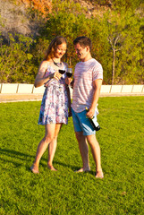 Naklejka premium Romantic moment in park, couple celebrate first year from wedding with red vine.