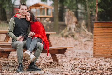 Young couple in the park outdoors at an authentic table in a cafe