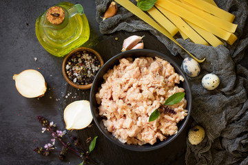 Minced meat, pasta and ingredients for cooking minced meat in a bowl on a slate.Top view flat lay background.