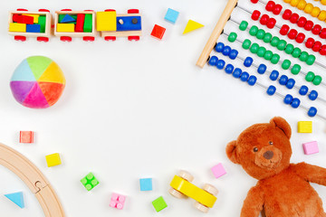Baby kids toys background with teddy bear, toy tools, wooden train, cars and colorful blocks. Top view, flat lay