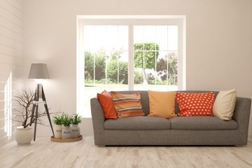 Naklejka premium Stylish room in white color with sofa and summer landscape in window. Scandinavian interior design. 3D illustration