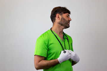 Portrait of male veterinary doctor in green uniform with brown hair defeated, facing forwards and...