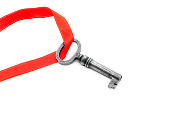 Vintage silver key with red ribbon on white background