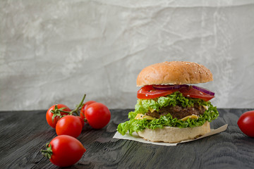 Fresh homemade burger on a dark table. Unhealthy food.