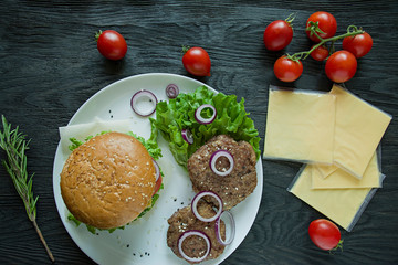 Fresh homemade burger on a white plate. Ingredients for cooking burger. Unhealthy food.
