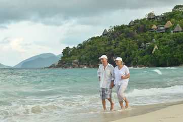 Portrait of elderly couple running on tropical beach