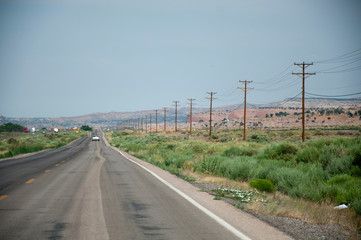 Straight road with telegraph poles in USA