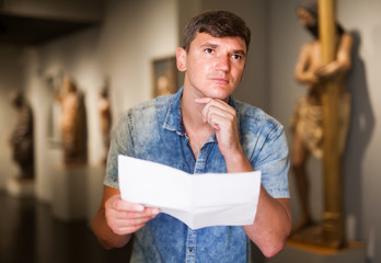 Man with information booklet in museum