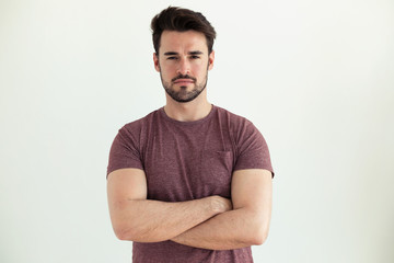 Serious young man looking at camera over white background.