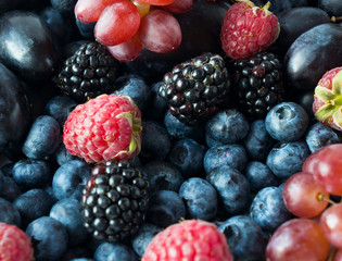 Ripe blackberries, blueberries, plums and raspberries. Mix berries and fruits. Top view. Background berries and fruits. Various fresh summer fruits. Black-blue and pink food.