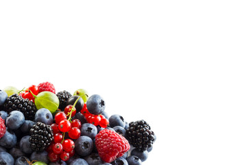 Mix berries on a white background. Ripe blueberries, red currants, backberries, gooseberries and raspberries on white background. Top view. Fruits and berries with copy space for text.