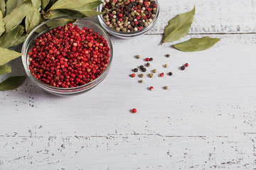 Assorted pepper spices. Pepper mix. Black, red and white peppercorns and dried bay laurel leaves on...