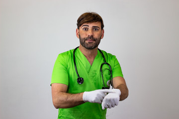 Portrait of male veterinary doctor in green uniform with brown hair looking impatient, their back facing the camera and looking at the camera. Isolated on white background.