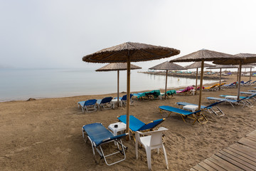 Umbrellas and sunbeds on the sea beach, early morning photo